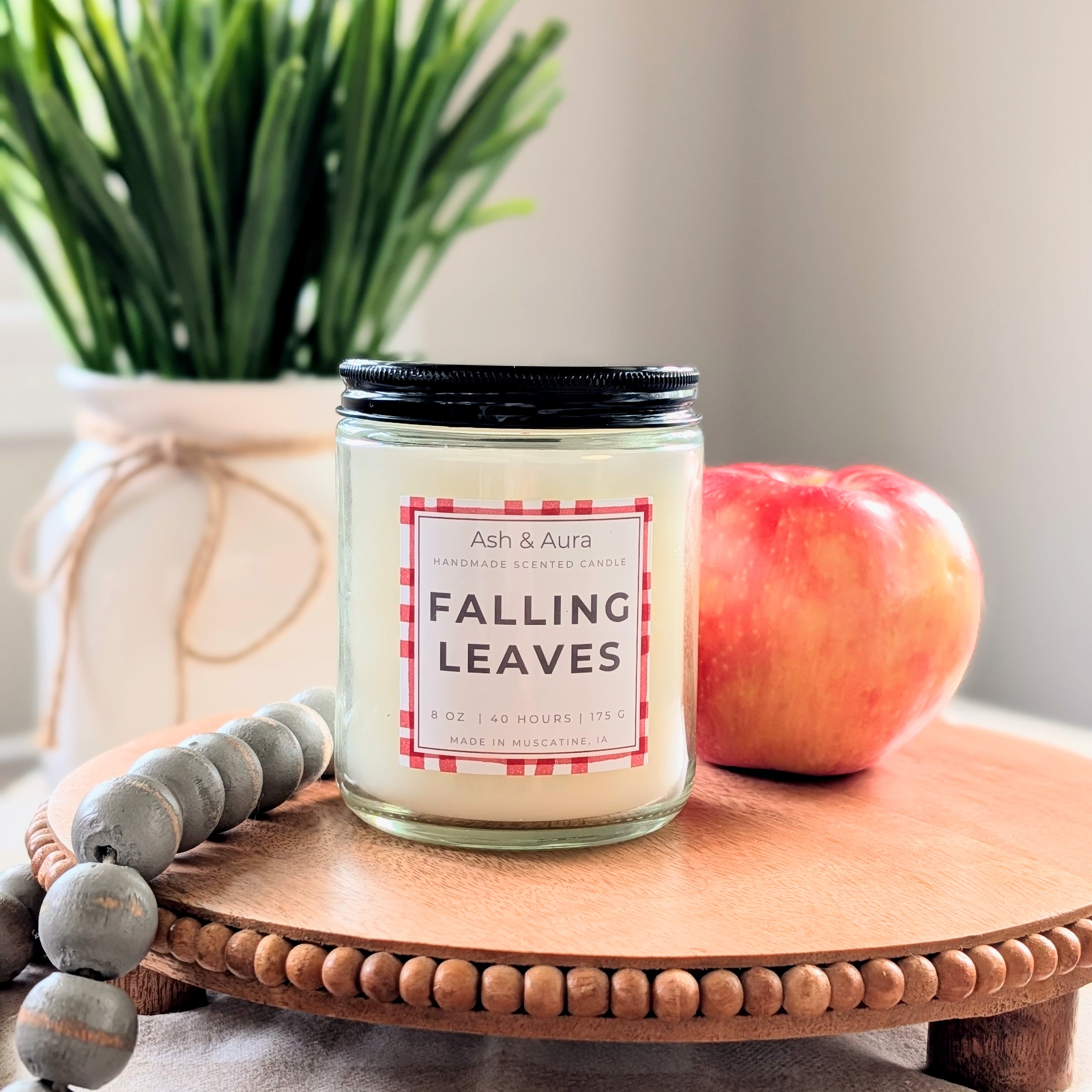 Falling Leaves soy blend candle in a [clear glass jar] with a white Ash & Aura label.