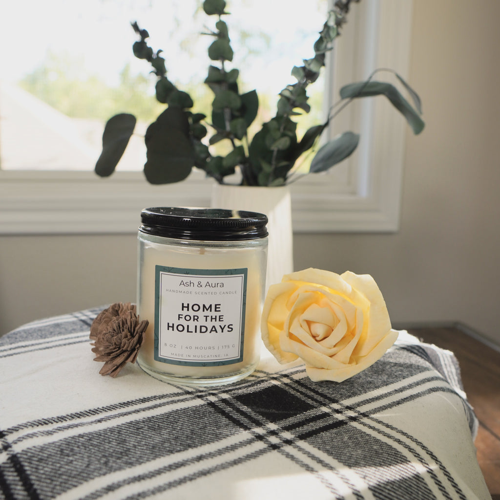 A close-up of the unlit Home for the Holidays candle.